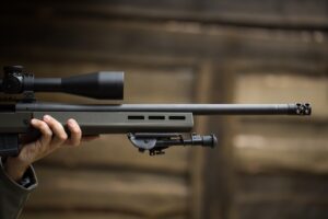 Man holding a large caliber rifle